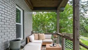 A covered porch with a sofa, a small table, and a lamp. - Downtown Walk Around (Blue Ridge)