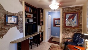 Una sala de estar con chimenea, televisión y estantería.