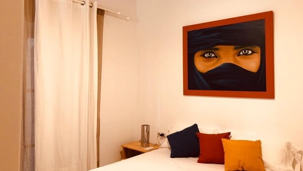 Une chambre d’hôtel avec un lit, une table de chevet, une lampe et un tableau au mur.