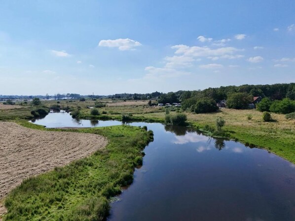 A river meandering through a rural landscape with fields and trees.