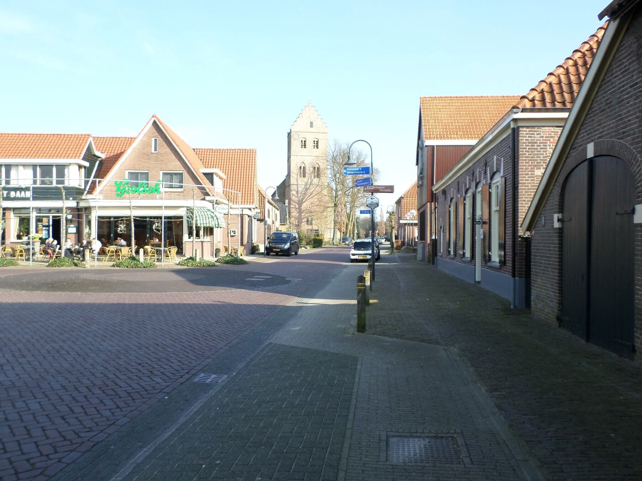 A street view with a restaurant, a church, and a row of shops.