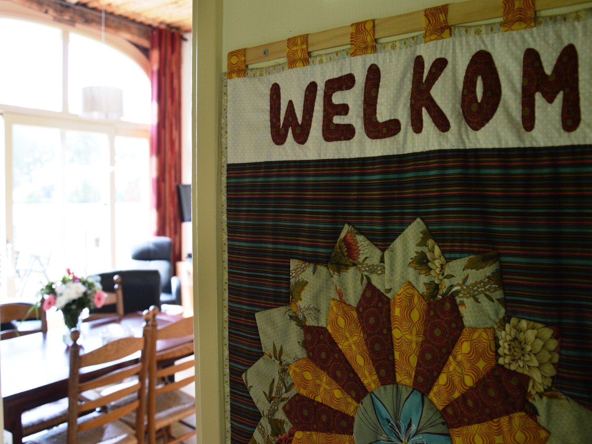 A room with a 'WELCOME' sign and a colorful quilt.
