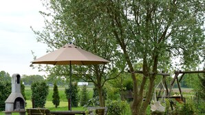 An outdoor seating area with a stone bench, a picnic table, and a grill. - Holiday Home in Holten near Lake IJssel (Holten)