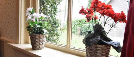 Two wicker baskets with flowers on a window sill.