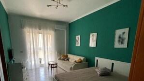 A bedroom with a bed, a sofa, and a desk. - 2 bedroom apartment in naples (Napoli)