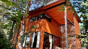 Una cabaña de madera moderna con ventanas amplias y una zona de patio.