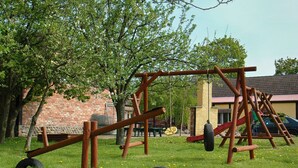 A playground with wooden structures and a tire swing.