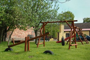 A playground with wooden structures and a tire swing.