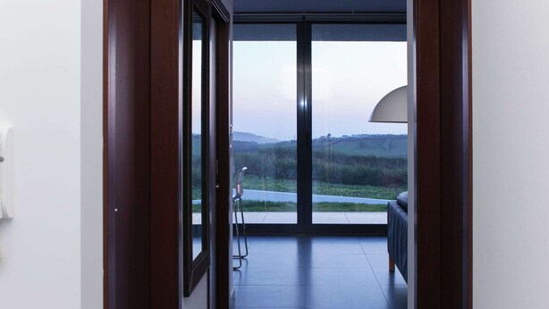 A modern interior with a view of a road and greenery outside. - Villa in Portugal with Sea View & Pool (Lourinhã)