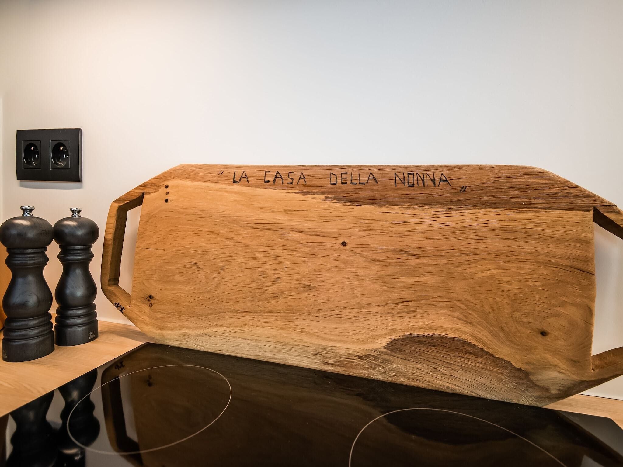Una escultura de madera con la inscripción 'LA CASA DELLA NONNA' en una pared.