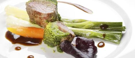 A plate with a piece of meat, broccoli, and vegetables.