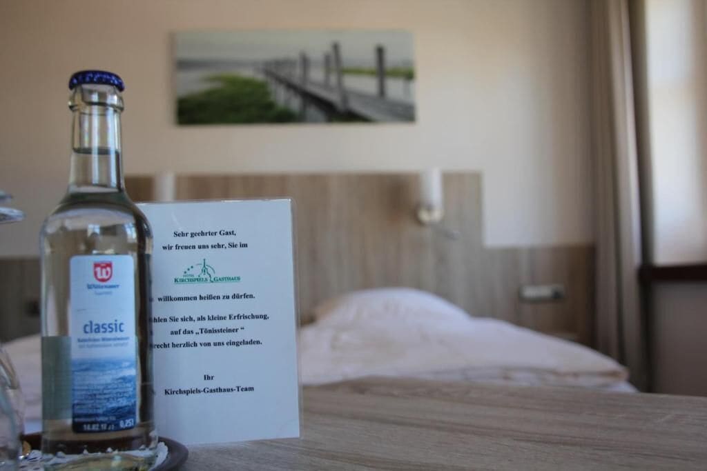 Een fles Kirschpfeil Gasthof op een tafel, met een bordje ernaast.
