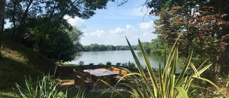 A lakeside view with a dock and a table set up for dining.