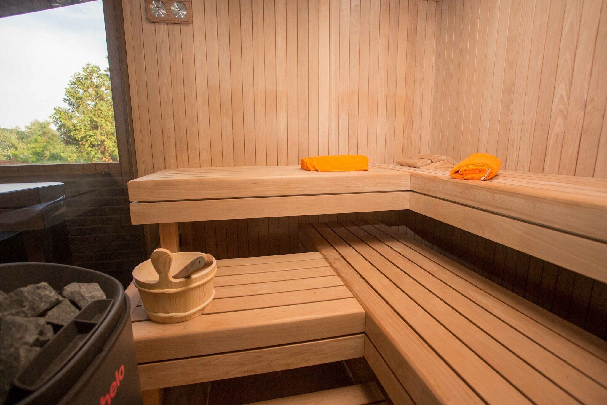 Un sauna avec des bancs en bois et un banc en bois avec une serviette.