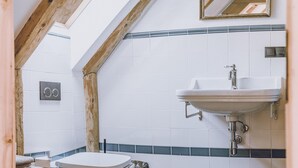 Un baño pequeño con inodoro, lavamanos y espejo.