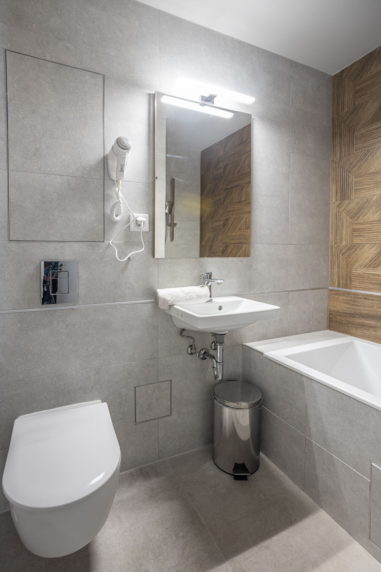 Un baño moderno con inodoro, lavamanos y bañera.