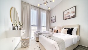 Une chambre d’hôtel moderne avec un grand lit, une table de chevet, un miroir et une fenêtre avec des rideaux.