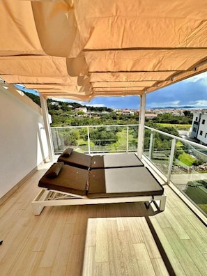 A balcony with a sun lounger, a view of a residential area, and a clear sky. - Villa 19 Julia apartment with sea view and 3 bedrooms (Tribunj)
