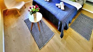 A bedroom with a bed, a chair, a small table with flowers, and a window. - Villa 19 Julia apartment with sea view and 3 bedrooms (Tribunj)