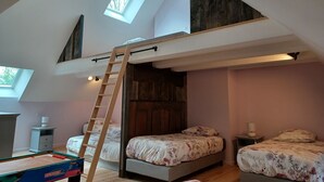 A loft bedroom with a loft bed, a small desk, and a futon bed. - Maison Restaurée: "lou Cantou des Randonneurs", Proche de Sentiers de Randonnées (chavagnac)