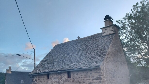 A stone building with a sloped roof, a chimney, and a small porch area. - Maison Restaurée: "lou Cantou des Randonneurs", Proche de Sentiers de Randonnées (chavagnac)