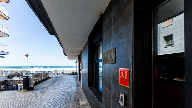 Entrada de um hotel à beira-mar, com vista para o oceano, uma galeria coberta e um teclado de segurança.