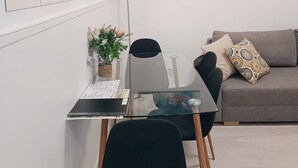 A modern living room with a glass dining table, a grey sofa, and a coffee table. There are two paintings of koi fish on the wall. - Apartment Frida - Nice, 150m from the beach by Egona (Zarautz)