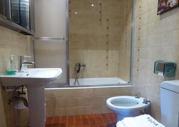 Ein Badezimmer mit Waschbecken, Toilette, Bidet und Dusche.