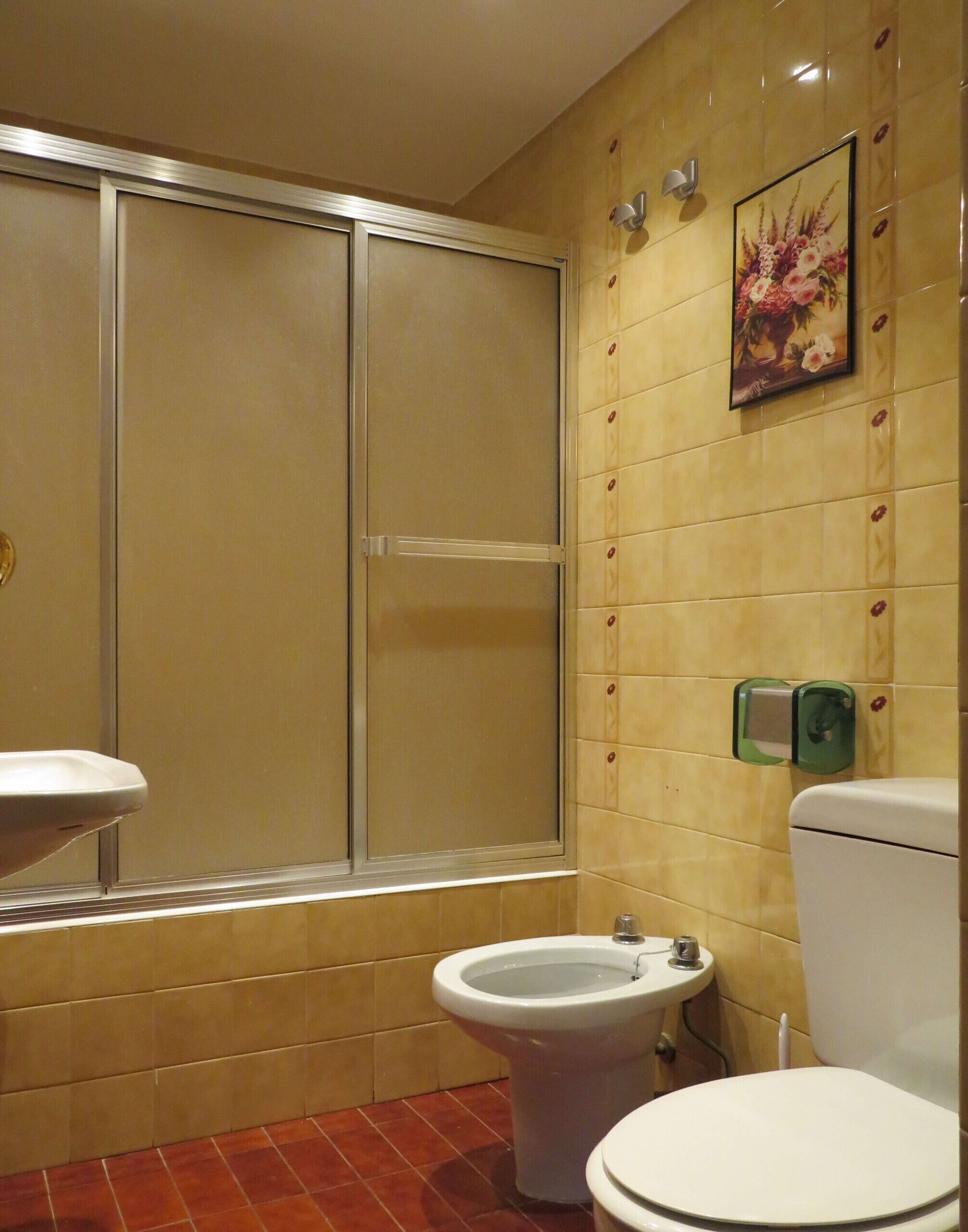 Un baño con inodoro, bidé y cabina de ducha.
