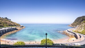 Une route côtière avec un pont, une plage et une mer bleue et limpide.