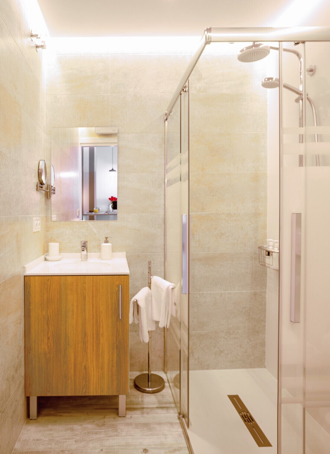 A modern bathroom with a glass-enclosed shower, a wooden vanity, and a mirror above the sink.