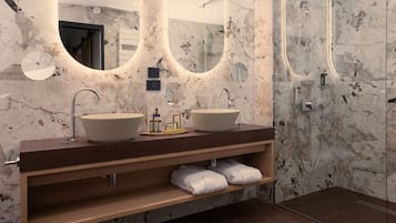 Ein modernes Badezimmer mit zwei Waschbecken, einem Spiegel und einer Dusche.