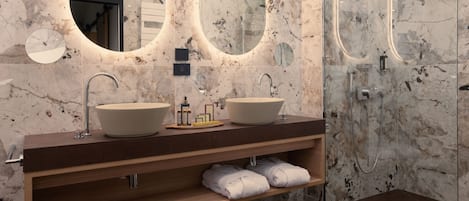 Un baño moderno con dos lavamanos, un espejo y una ducha.