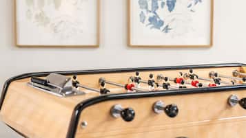 Una mesa de fútbol de mesa en una habitación con dos obras de arte enmarcadas en la pared.