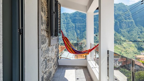 A balcony with a hammock, a view of green mountains, and a clear sky. - Basalt House B by Homie (São Vicente)