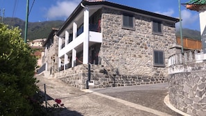Standalone building with a traditional stone facade and balcony offering a view of the surrounding area.