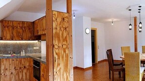 Une cuisine moderne avec des meubles en bois et un coin repas comprenant une table et des chaises.