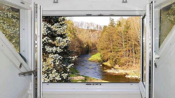 A room with a large window offering a view of a river and forest. - Villa Rotschoenberg im Tal der Freiberger Mulde (Großschirma)