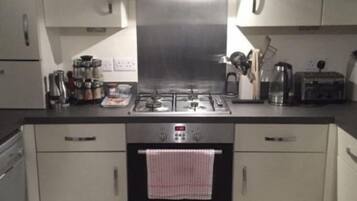 A modern kitchen with stainless steel appliances, including a stove, oven, and toaster. There are cabinets and a countertop with various kitchen items.