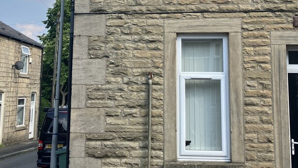 A stone building with two windows, a door, and a street lamp. - Immaculate 2-bed Apartment in Bury (Bury)