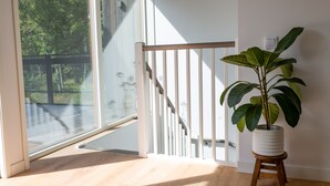 A room with a large window, a staircase, and a potted plant. - Halltorp Townhouse (Borgholm)
