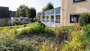 Zona residencial amb una casa que destaca per les seves grans finestres i un jardí.