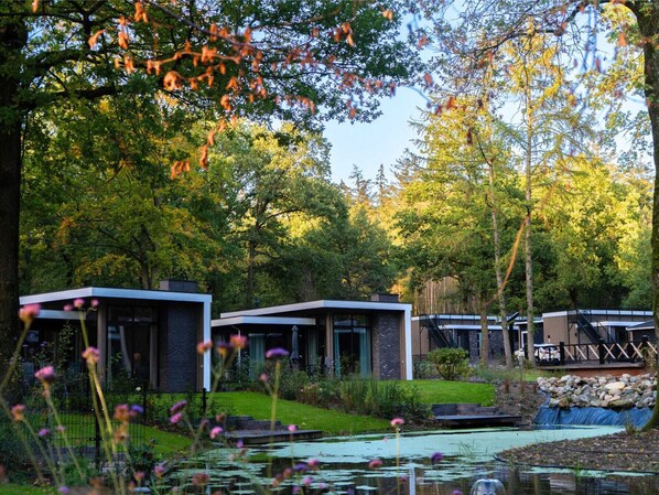 A modern building with a pond and surrounding greenery. - Nature-Connected Modern Stay (Hoenderloo)