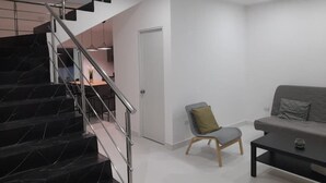 Un intérieur moderne comprenant un escalier, un coin repas et un espace salon avec un canapé et une table basse.