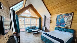 A bedroom with a large bed, a sofa, a TV, and a fireplace. - Bayan Mongolian Resort - Genghis Khan Statue (Erdene)