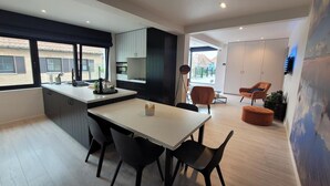 A modern kitchen with a dining area, large windows, and a view of the outside. - Apartment in Zuienkerke with Terrace (zuienkerke)