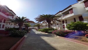A residential street with white buildings, palm trees, and a clear sky. - Belvilla by OYO Apartment in Arona (Arona)