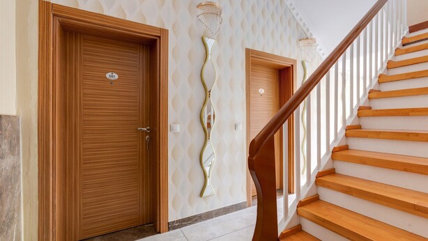 A staircase with wooden steps leading to a landing, flanked by two wooden doors with a 'Sofitel' sign. - Apartment in Oberhausen near Lake & River (Oberhausen)