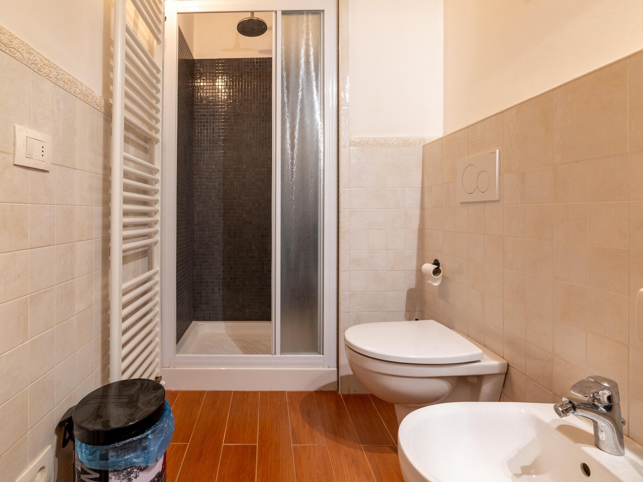 A bathroom with a shower, toilet, and sink.