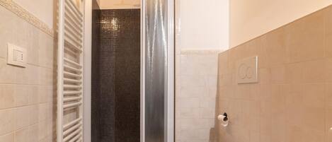 A bathroom with a shower, toilet, and sink.